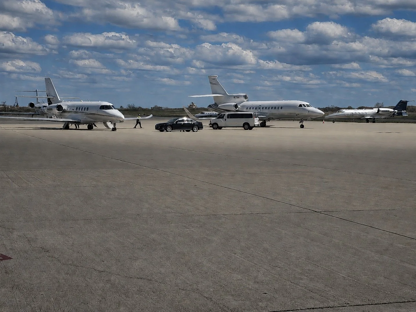 Private aircraft and ground transportation positioned on an airport ramp.